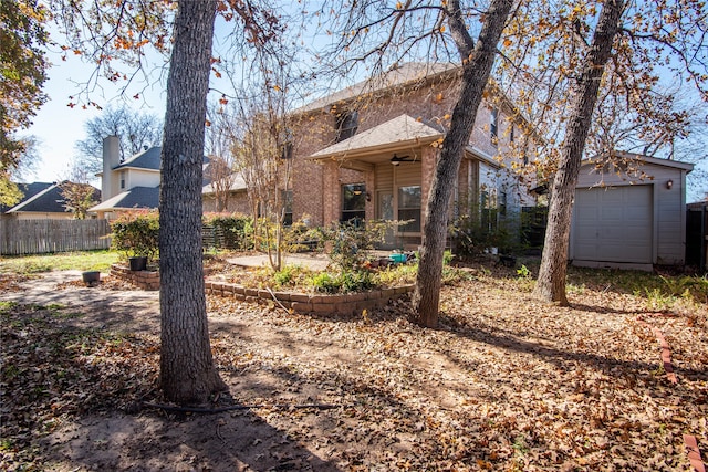 exterior space featuring a garage, an outbuilding, and ceiling fan