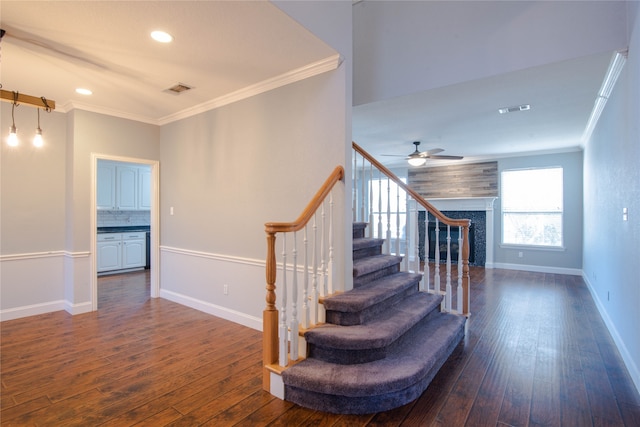 stairway with ceiling fan, ornamental molding, and hardwood / wood-style flooring