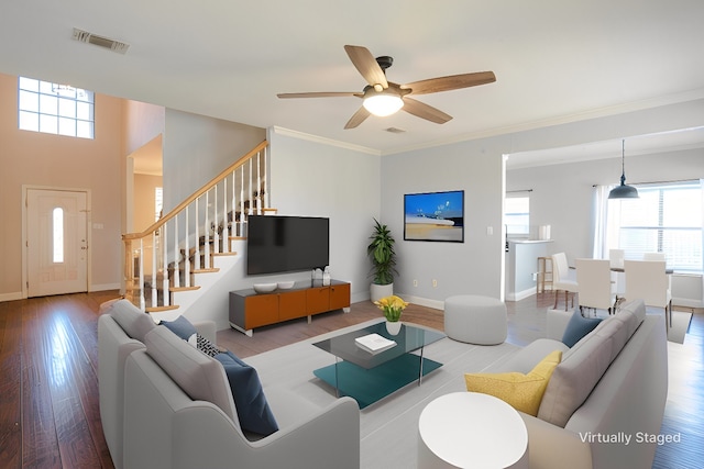 living room featuring ornamental molding, ceiling fan, and light wood-type flooring