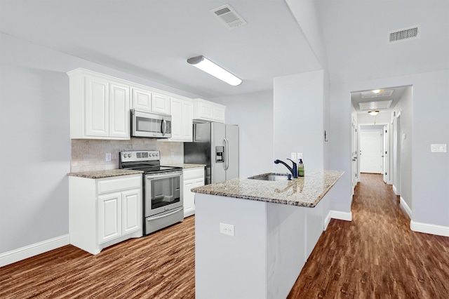 kitchen with sink, white cabinets, wood-type flooring, and appliances with stainless steel finishes