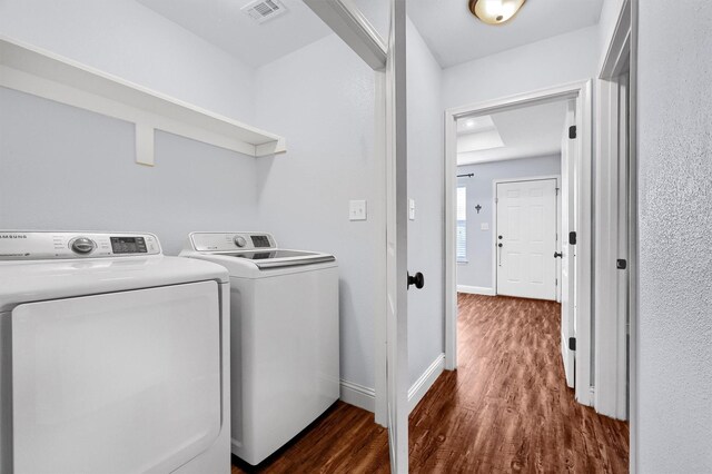 laundry area with washer and dryer and dark wood-type flooring