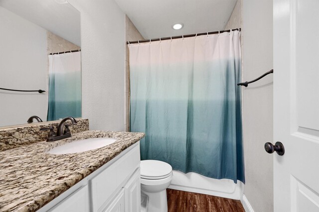 full bathroom featuring shower / bath combination with curtain, vanity, wood-type flooring, and toilet