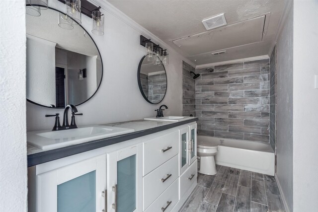 full bathroom with vanity, crown molding, wood-type flooring, toilet, and tiled shower / bath