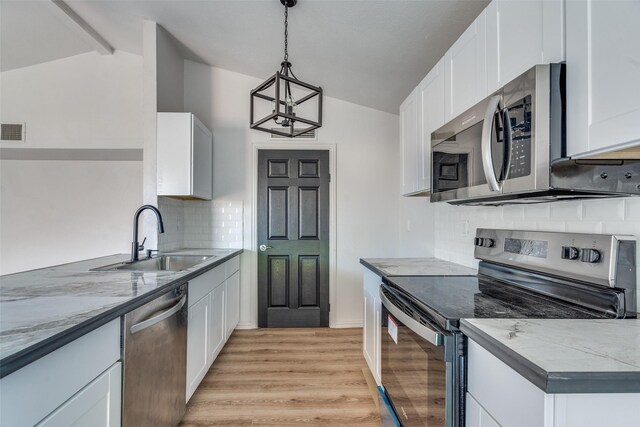 kitchen with vaulted ceiling with beams, sink, white cabinets, and appliances with stainless steel finishes