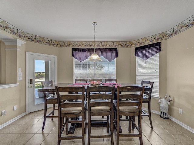 dining space featuring light tile patterned floors, ornate columns, and baseboards