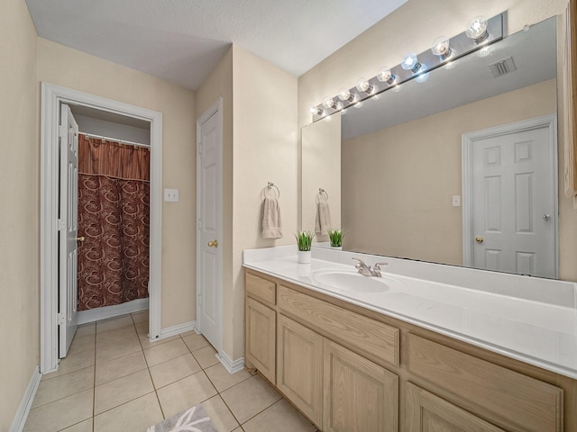 bathroom with tile patterned flooring, vanity, a shower with curtain, and a textured ceiling