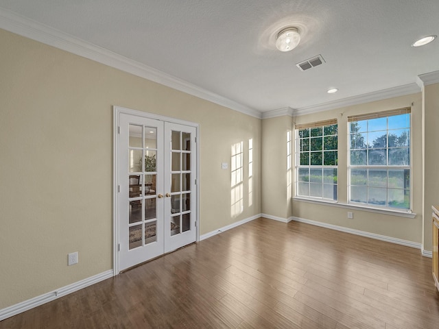 spare room with french doors, a textured ceiling, crown molding, and hardwood / wood-style floors