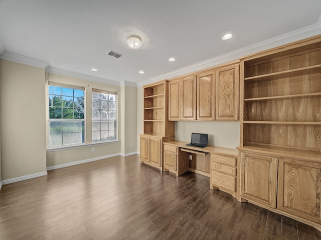 unfurnished office featuring built in desk, dark hardwood / wood-style floors, and ornamental molding