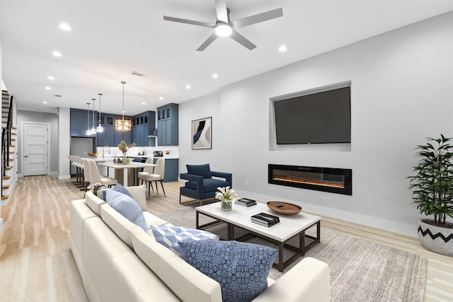 living room with ceiling fan and light hardwood / wood-style flooring