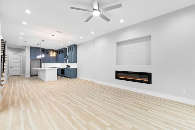 unfurnished living room with light hardwood / wood-style flooring and ceiling fan