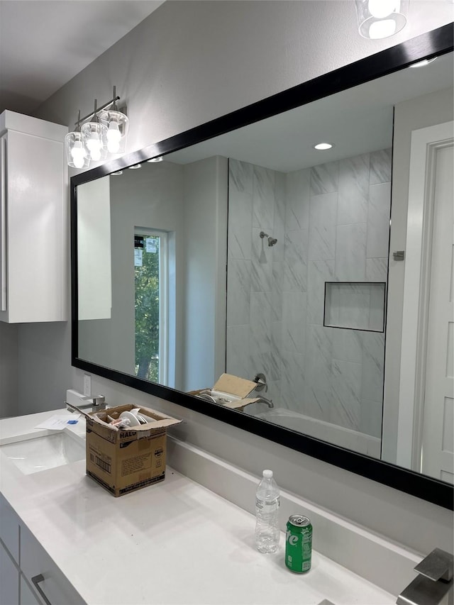 bathroom featuring tiled shower / bath and vanity