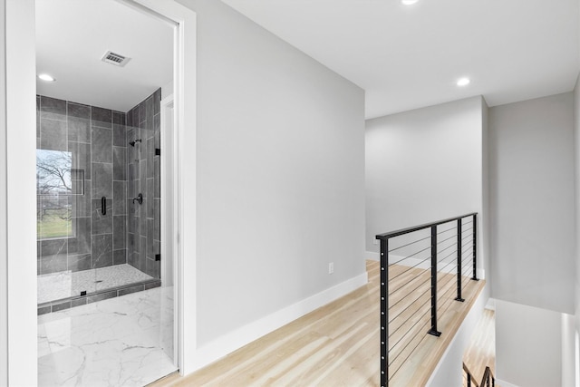 bathroom featuring walk in shower and hardwood / wood-style flooring