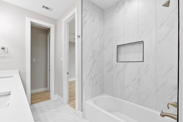 bathroom with vanity and tiled shower / bath combo