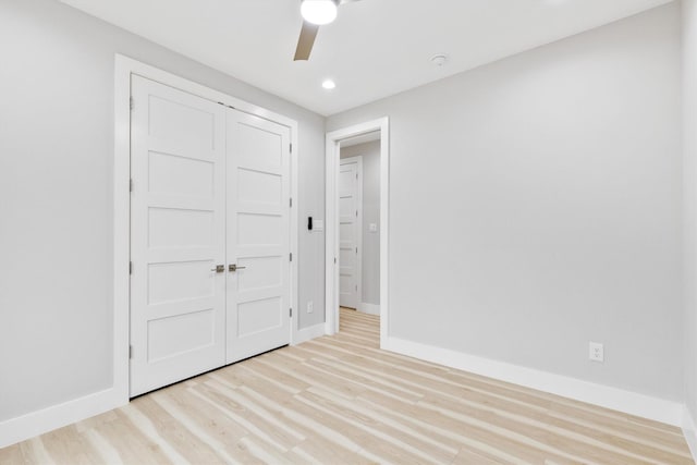 unfurnished bedroom with ceiling fan, light hardwood / wood-style floors, and a closet