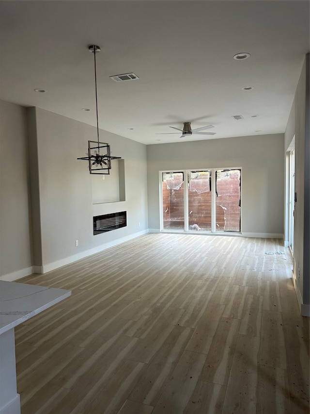 unfurnished living room featuring hardwood / wood-style flooring and ceiling fan