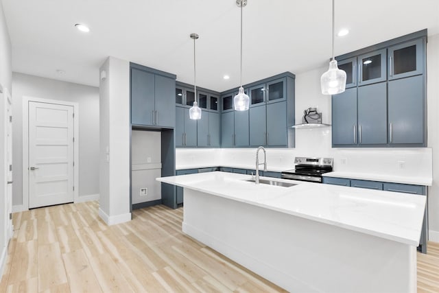 kitchen featuring blue cabinets, a kitchen island with sink, sink, and stainless steel electric range