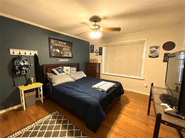 bedroom featuring hardwood / wood-style flooring, ornamental molding, and ceiling fan