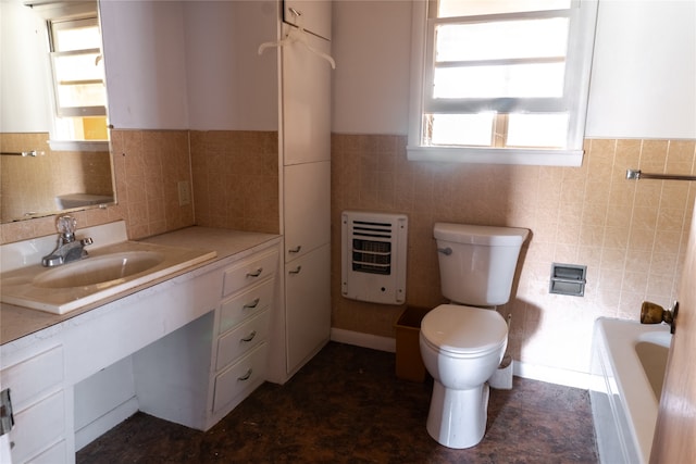 bathroom featuring toilet, heating unit, tile walls, vanity, and a tub