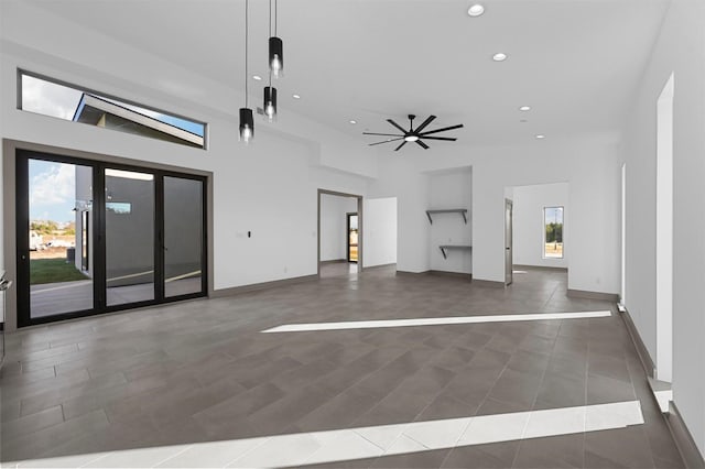 interior space with ceiling fan and a towering ceiling