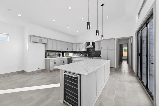 kitchen with a center island, gray cabinets, plenty of natural light, and beverage cooler