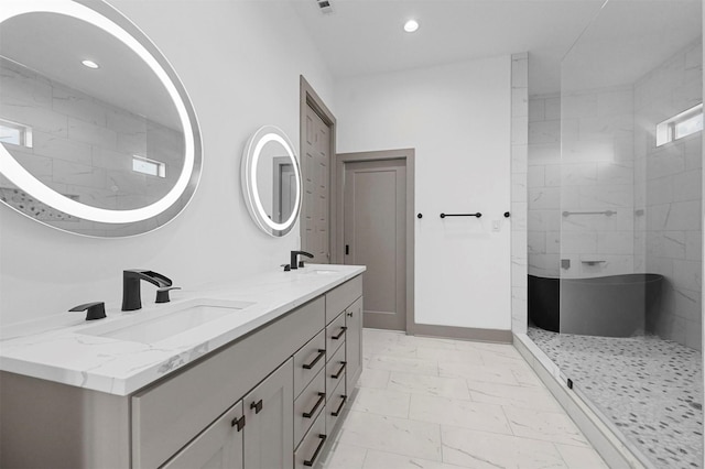 bathroom with a tile shower and vanity