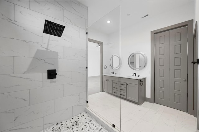 bathroom featuring tiled shower and vanity