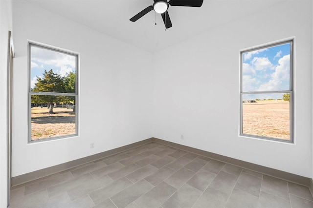 spare room with ceiling fan and a healthy amount of sunlight