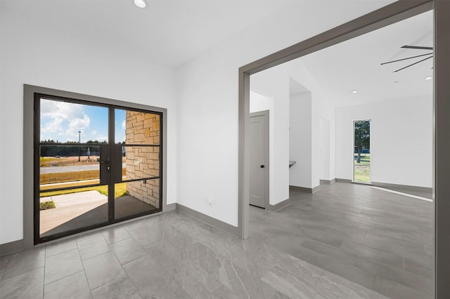 empty room featuring ceiling fan and french doors