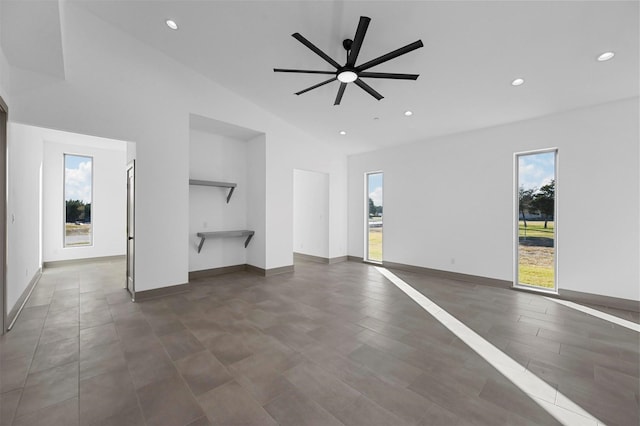 unfurnished living room with ceiling fan and vaulted ceiling