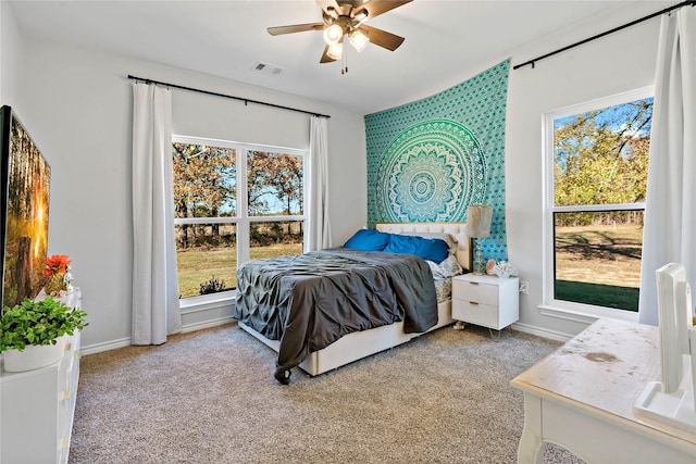 bedroom featuring multiple windows, ceiling fan, and carpet flooring