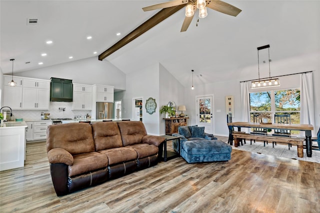 living room featuring sink, high vaulted ceiling, light hardwood / wood-style floors, and beamed ceiling