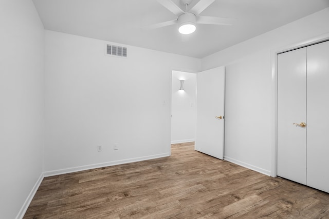 unfurnished bedroom featuring a closet, light hardwood / wood-style flooring, and ceiling fan