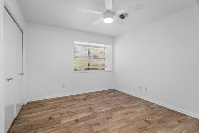 unfurnished bedroom featuring hardwood / wood-style floors, a closet, and ceiling fan