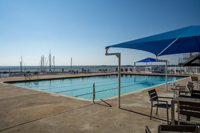 view of pool with a patio area and a water view