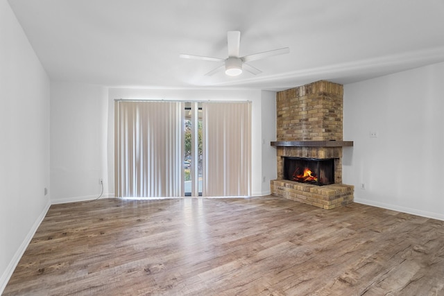 unfurnished living room featuring a fireplace, wood-type flooring, and ceiling fan