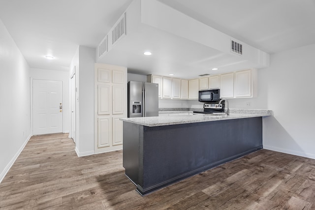 kitchen featuring wood-type flooring, kitchen peninsula, and appliances with stainless steel finishes