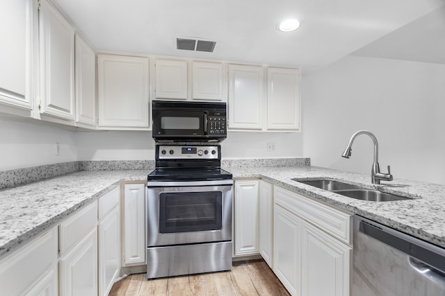 kitchen featuring light stone countertops, appliances with stainless steel finishes, light wood-type flooring, sink, and white cabinets