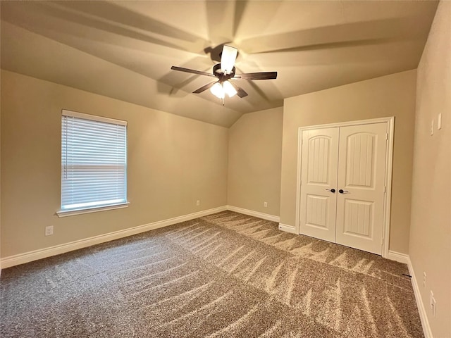 carpeted empty room with ceiling fan and lofted ceiling