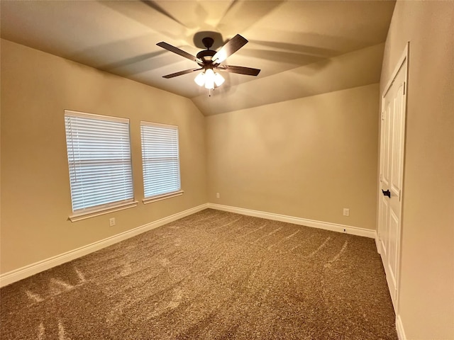 carpeted spare room with ceiling fan and vaulted ceiling