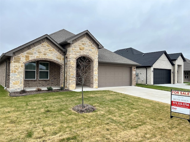 french country inspired facade with a front yard and a garage