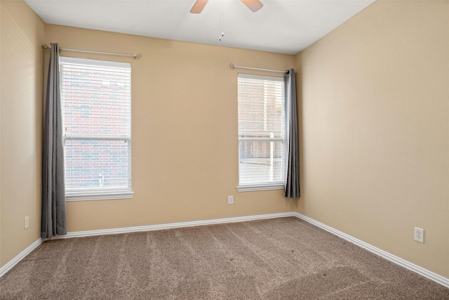 carpeted spare room featuring a wealth of natural light and ceiling fan