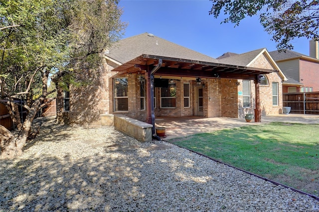 rear view of property with a patio area, ceiling fan, and a yard