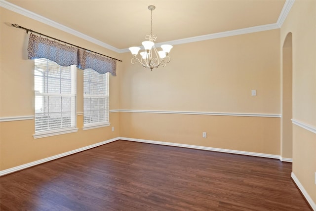 empty room featuring crown molding, dark wood-type flooring, and a notable chandelier