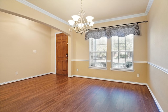 empty room featuring hardwood / wood-style flooring, crown molding, and a chandelier