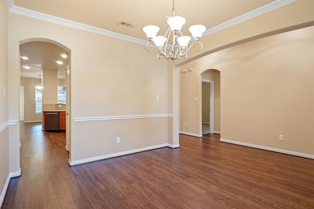 spare room with dark hardwood / wood-style flooring, ornamental molding, and a notable chandelier