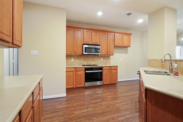 kitchen with backsplash, sink, dark wood-type flooring, and appliances with stainless steel finishes