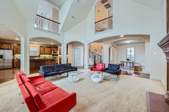 living room featuring wood-type flooring and a towering ceiling