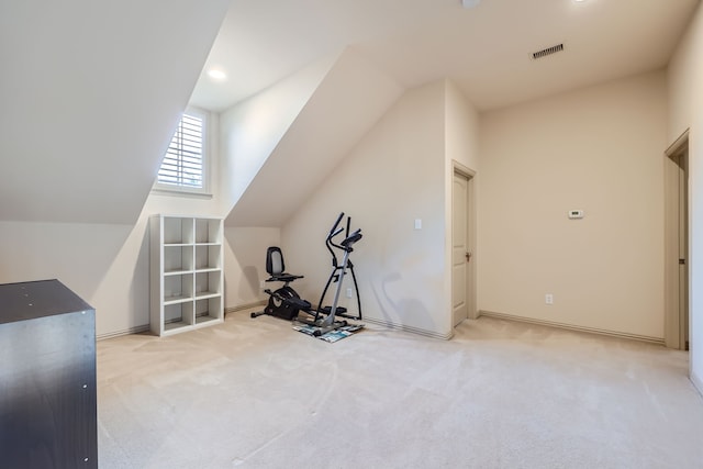 workout room featuring light colored carpet and vaulted ceiling