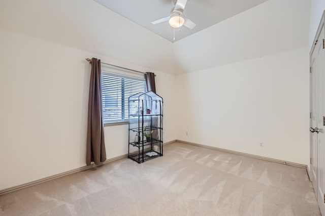 carpeted spare room featuring vaulted ceiling and ceiling fan