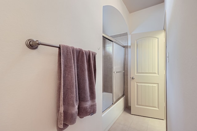 bathroom with tile patterned flooring and bath / shower combo with glass door